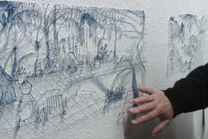 Hand drückt ausgeschnittene Zeichnung an die Wand