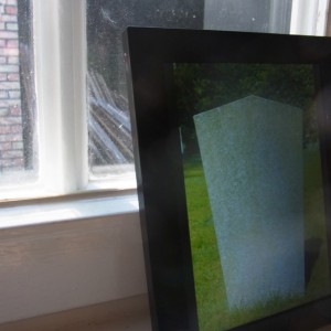Foto im digitalen Bilderrahmen: Rueckseite eines Grabsteins