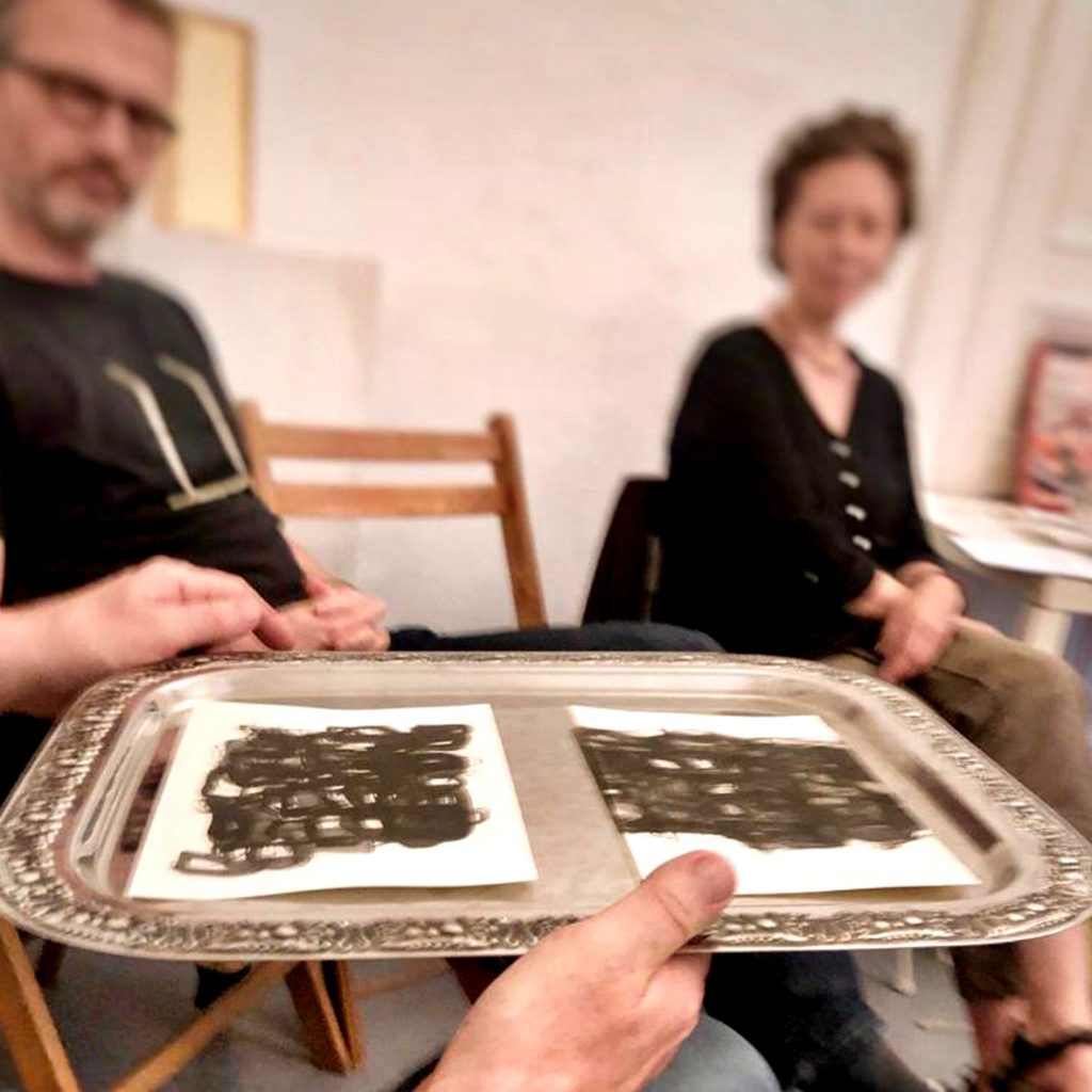 Salon Waldeinsamkeit bei puzzelink, Zeichnungen der Künstlerin EVA werden auf einem Silbertablett umhergereicht.