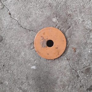 Runder Verschluss auf grauem Betonboden in der Hütte des Goldschimmels