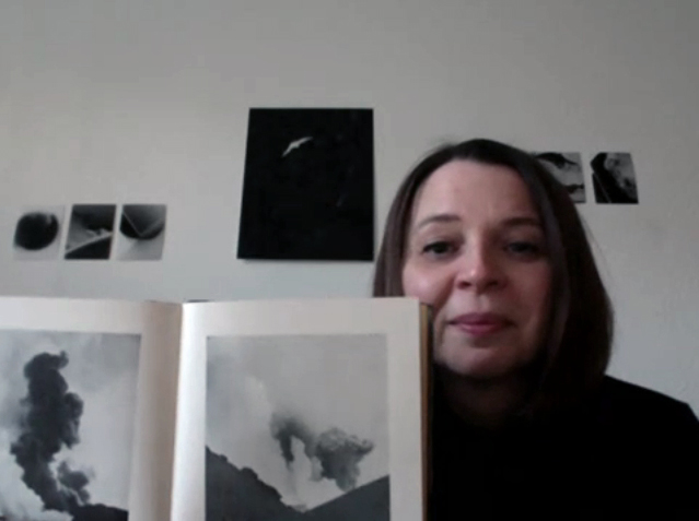 Sabine Höpfner mit dem Buch Heklugos vor einer Wand miteigenen Fotos aus Island
