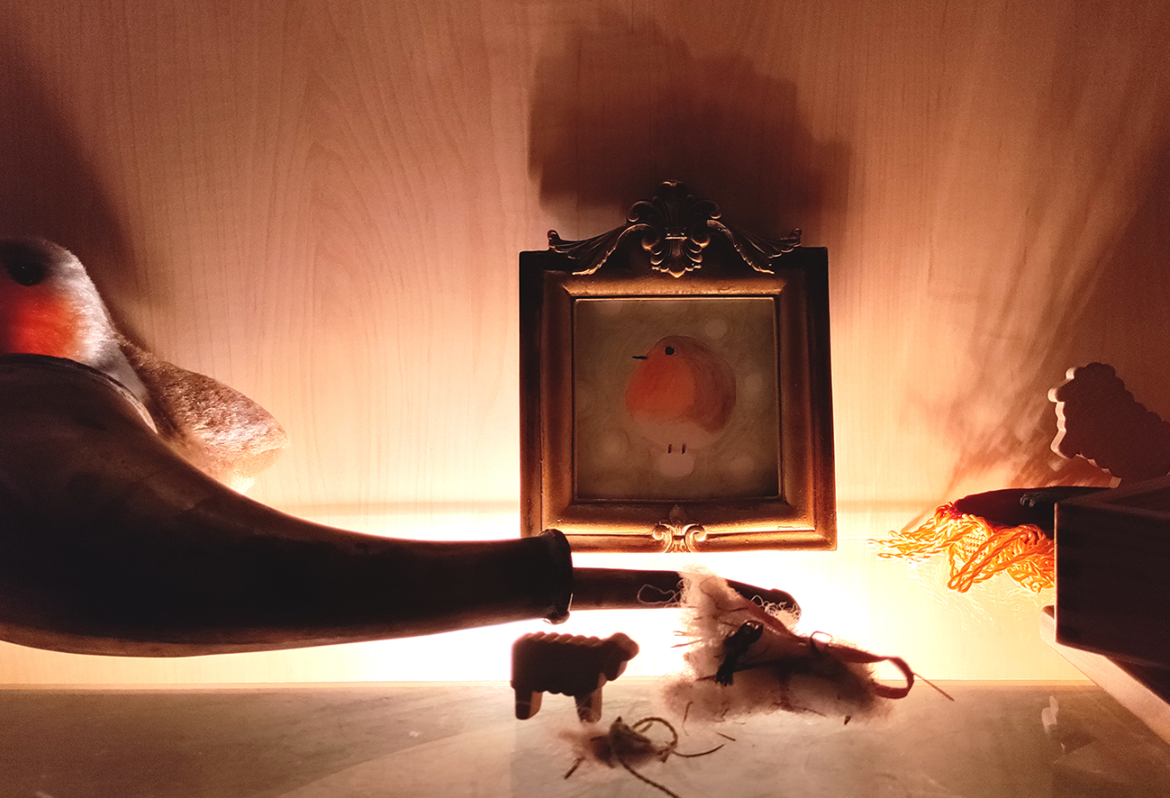 Blick in einen beleuchteten Schrank mit Kunstwerken von EVA.